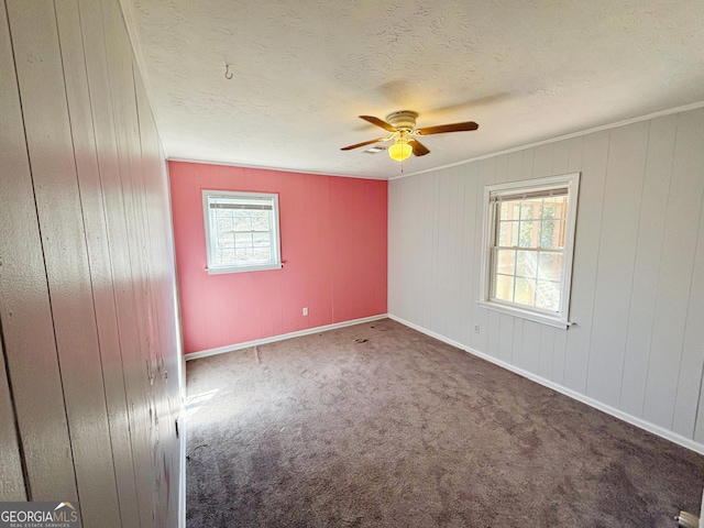 carpeted empty room with ceiling fan and a textured ceiling