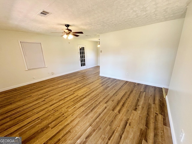 spare room with ceiling fan, a textured ceiling, and hardwood / wood-style floors