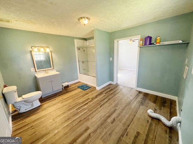 full bathroom featuring bath / shower combo with glass door, vanity, toilet, and hardwood / wood-style floors