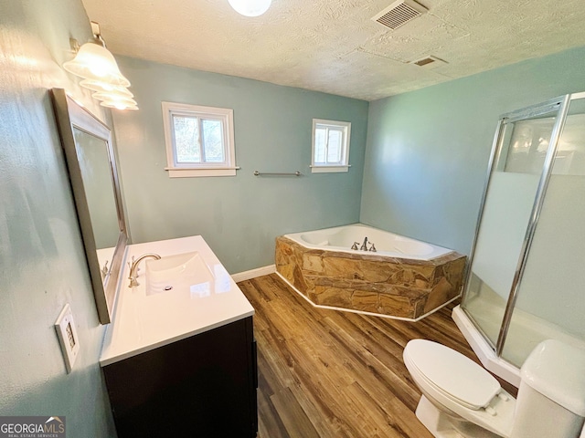 full bathroom featuring hardwood / wood-style floors, a textured ceiling, plus walk in shower, and vanity