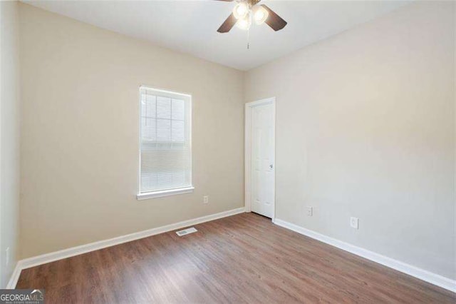 spare room with ceiling fan and wood-type flooring