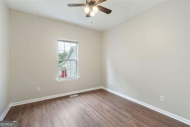 unfurnished room featuring ceiling fan and dark wood-type flooring