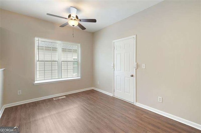 spare room featuring ceiling fan and dark wood-type flooring