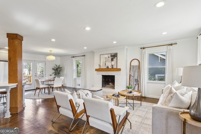 living room with hardwood / wood-style flooring, french doors, and a brick fireplace