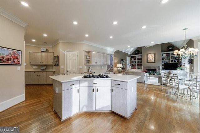 kitchen featuring a kitchen island, gas stovetop, decorative light fixtures, and light hardwood / wood-style floors