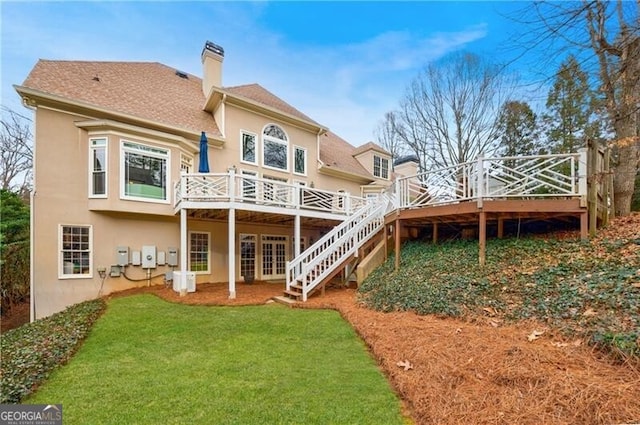 rear view of property featuring a deck and a yard