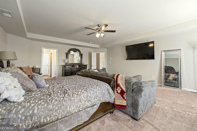 carpeted bedroom featuring ceiling fan and a raised ceiling