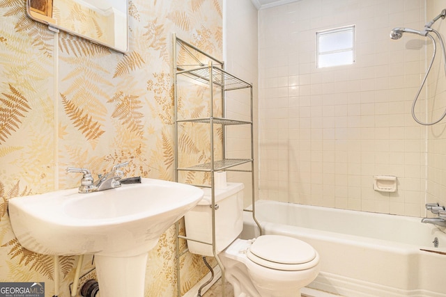 full bathroom with a sink, bathtub / shower combination, toilet, and wallpapered walls