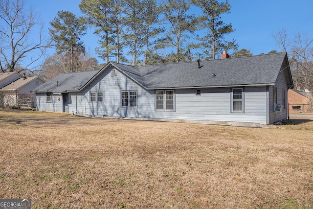 back of house with a shingled roof, cooling unit, a lawn, and a chimney