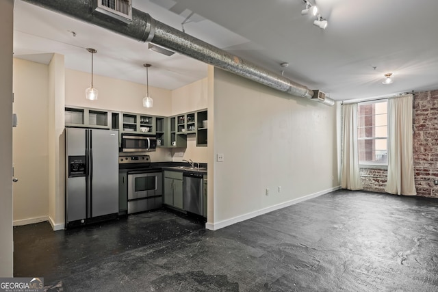 kitchen with appliances with stainless steel finishes, decorative light fixtures, sink, and brick wall