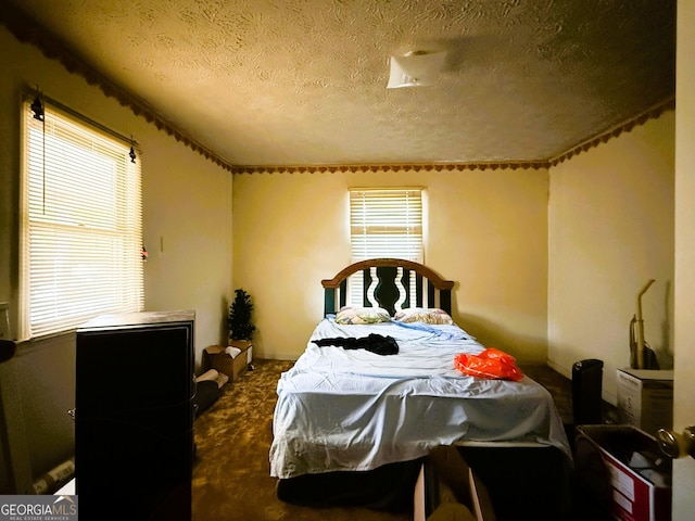 bedroom featuring dark carpet and a textured ceiling