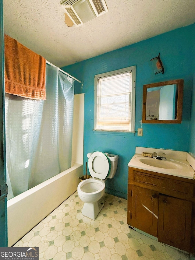 full bathroom with shower / bath combo, a textured ceiling, vanity, and toilet