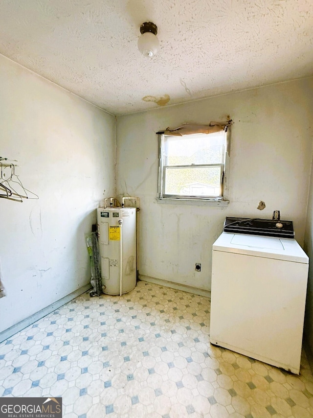 laundry room with a textured ceiling, washer / clothes dryer, and water heater