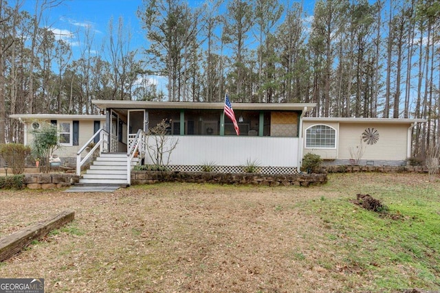 view of front facade with a front lawn and a sunroom