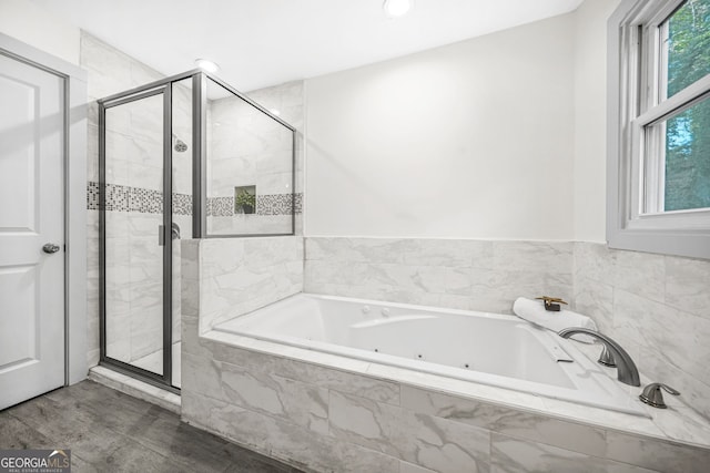 bathroom with shower with separate bathtub and wood-type flooring