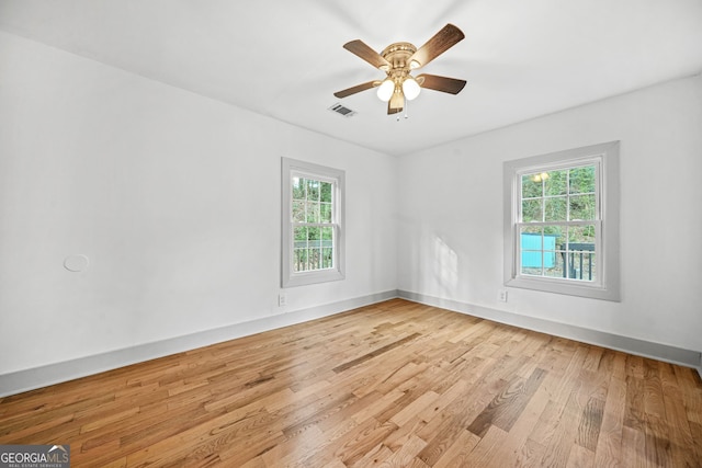 empty room with ceiling fan and light hardwood / wood-style flooring