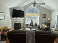 living room featuring lofted ceiling, ceiling fan, and hardwood / wood-style flooring