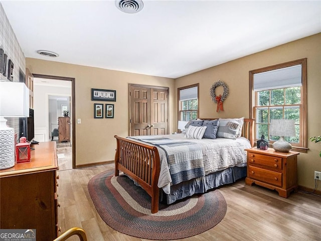 bedroom with light wood-type flooring and a closet