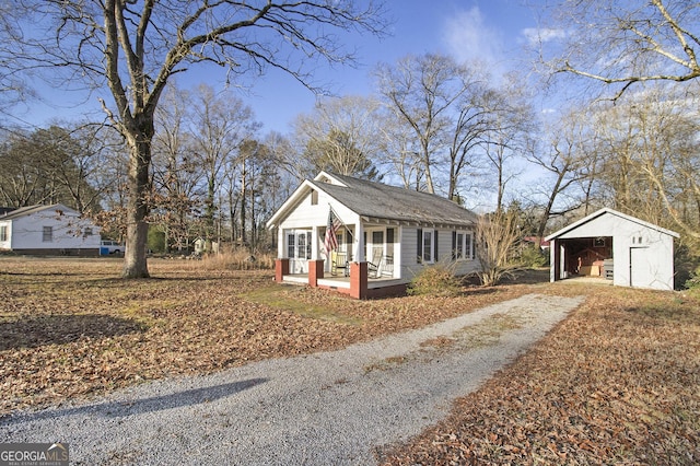 single story home with an outbuilding, a garage, covered porch, and a carport