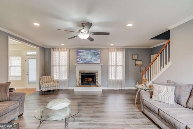 living room with a healthy amount of sunlight, wood finished floors, and stairs