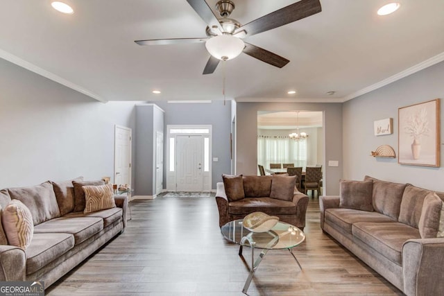 living room with recessed lighting, ornamental molding, and wood finished floors