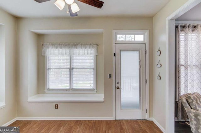 foyer with a ceiling fan, wood finished floors, and baseboards