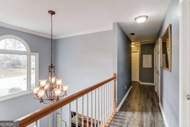 hall featuring visible vents, baseboards, an upstairs landing, wood finished floors, and a notable chandelier