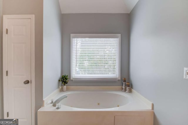 bathroom featuring a closet and a whirlpool tub