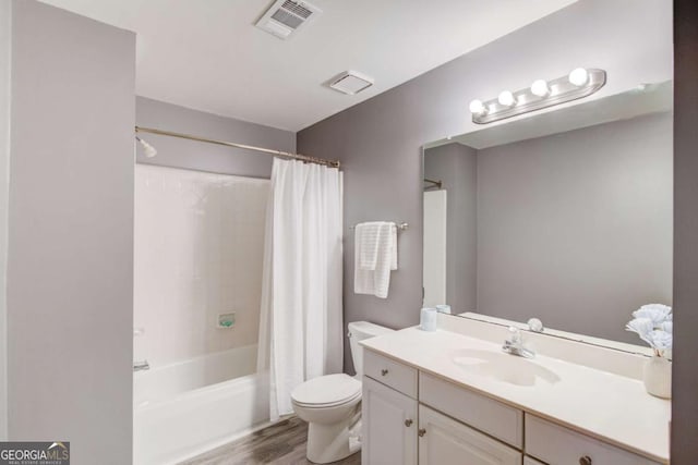 bathroom with visible vents, toilet, shower / bath combo, wood finished floors, and vanity