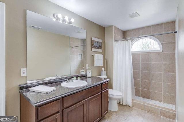 bathroom featuring tile patterned floors, visible vents, toilet, a tile shower, and vanity