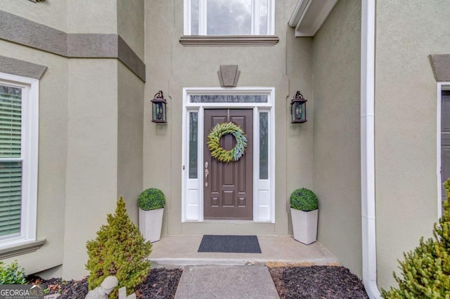 view of exterior entry featuring stucco siding