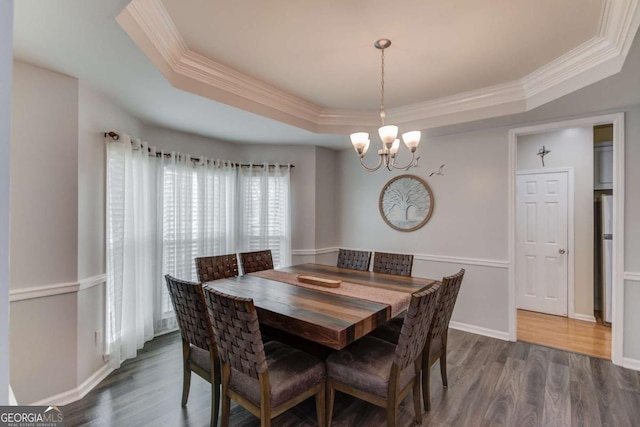 dining area with dark wood finished floors, baseboards, crown molding, and a tray ceiling