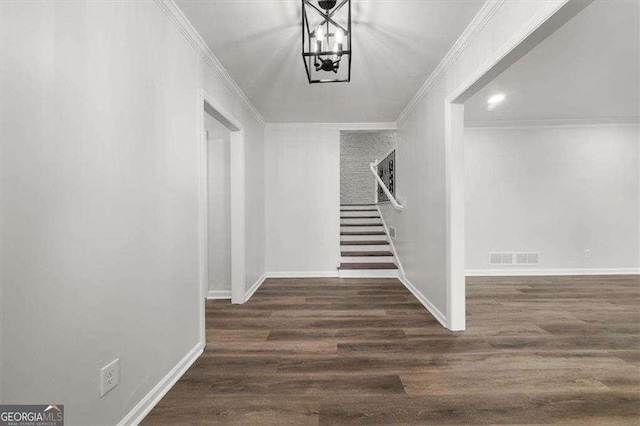 entryway with ornamental molding, stairs, visible vents, and dark wood-style flooring