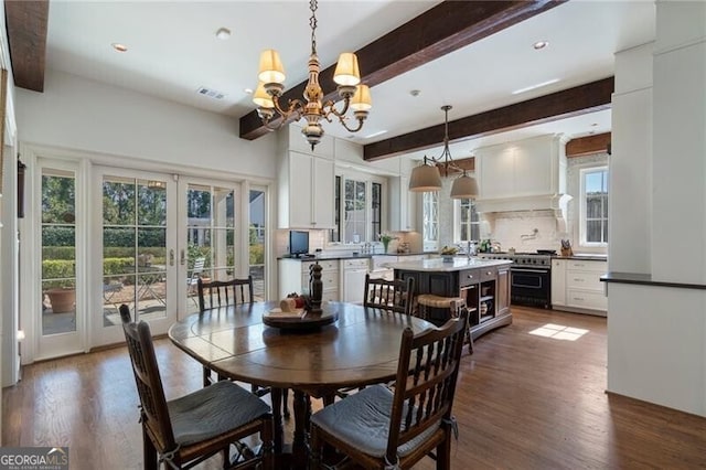 dining room featuring beamed ceiling, french doors, hardwood / wood-style floors, and a chandelier