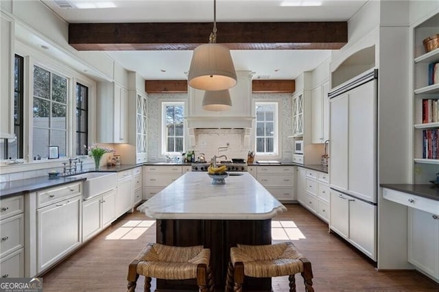 kitchen featuring a center island, beam ceiling, sink, and decorative light fixtures