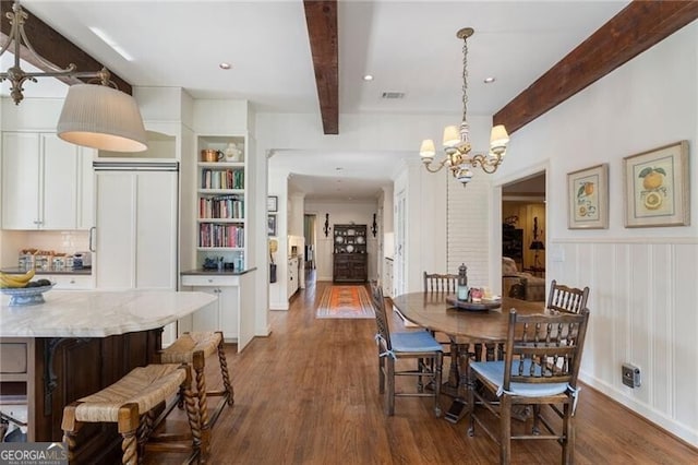 dining area with a chandelier, dark wood-type flooring, and beam ceiling