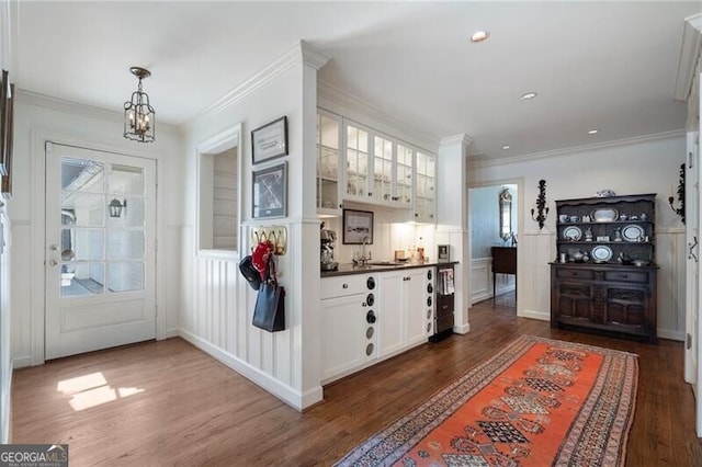 foyer featuring sink, crown molding, dark hardwood / wood-style floors, and a notable chandelier