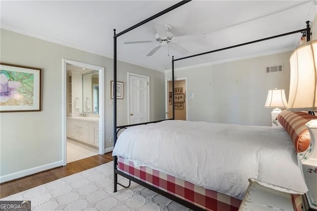 bedroom featuring hardwood / wood-style floors, ceiling fan, crown molding, and connected bathroom