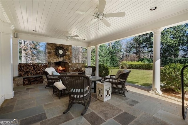 view of patio with an outdoor living space with a fireplace and ceiling fan