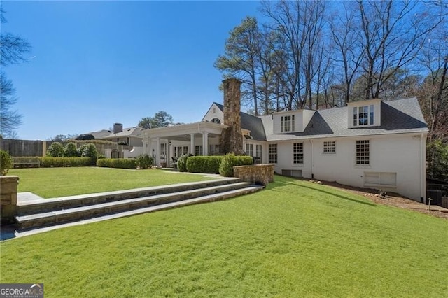 rear view of house featuring a yard