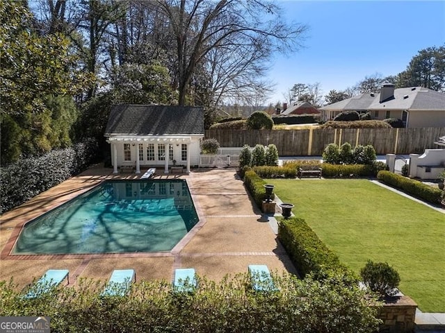 view of pool with a patio, a yard, and an outdoor structure