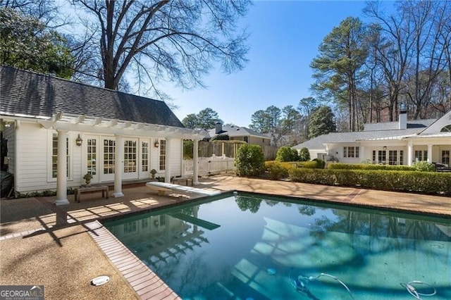 view of pool featuring an outbuilding, french doors, a patio, and a diving board