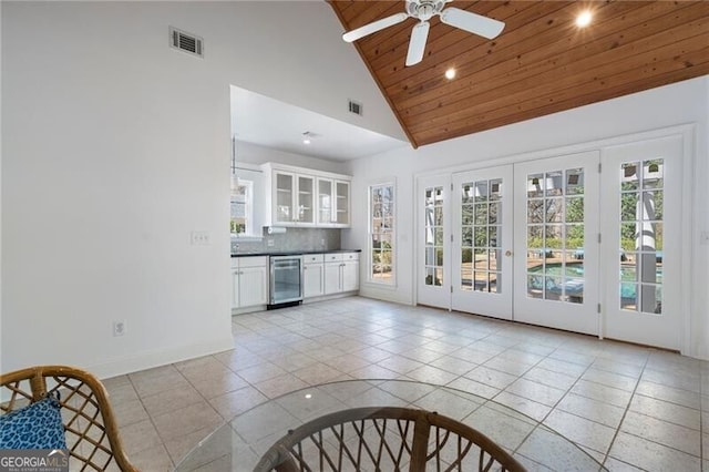 interior space featuring french doors, wine cooler, ceiling fan, wooden ceiling, and high vaulted ceiling