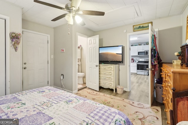 bedroom featuring ensuite bath, light hardwood / wood-style flooring, and ceiling fan