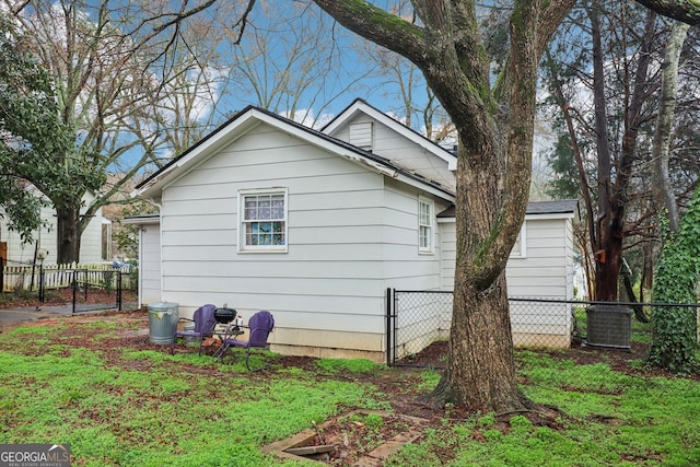 view of side of property featuring central AC unit and a lawn