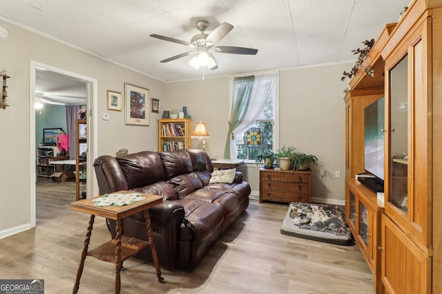 living room with light wood-type flooring, crown molding, and ceiling fan