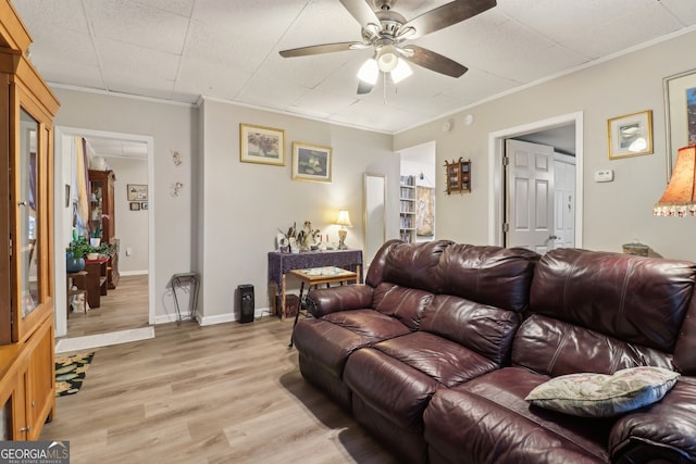 living room with light hardwood / wood-style floors, crown molding, and ceiling fan