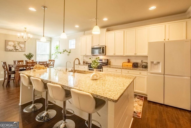 kitchen featuring appliances with stainless steel finishes, an island with sink, pendant lighting, ornamental molding, and sink