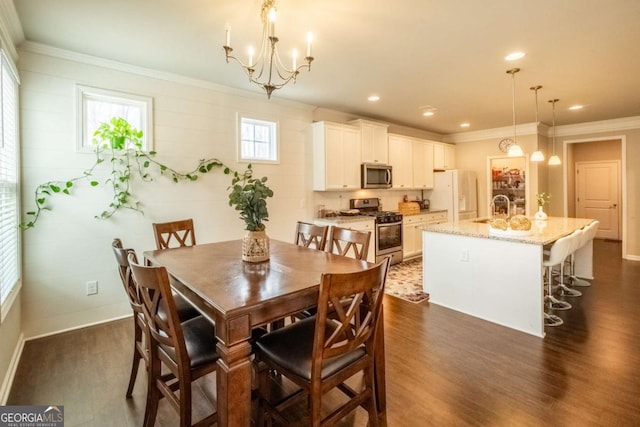 dining room with ornamental molding, dark wood-type flooring, sink, and a chandelier