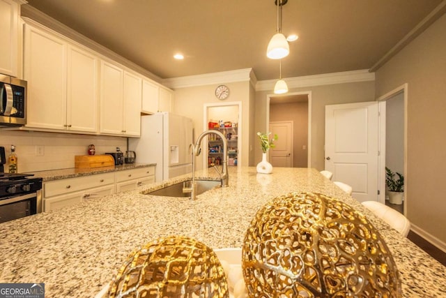 kitchen featuring light stone counters, pendant lighting, crown molding, sink, and white cabinetry